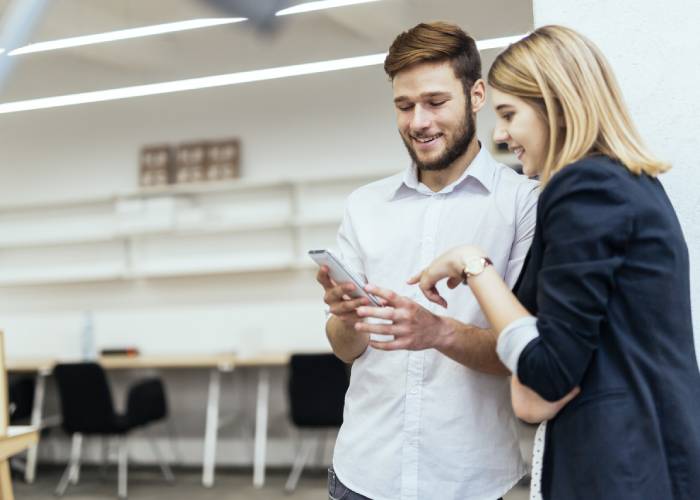 A guy and a girl looking at the phone